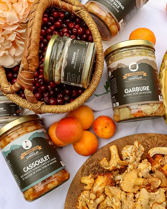Bocaux de conserves, abricots et girolles disposés autour d'un panier